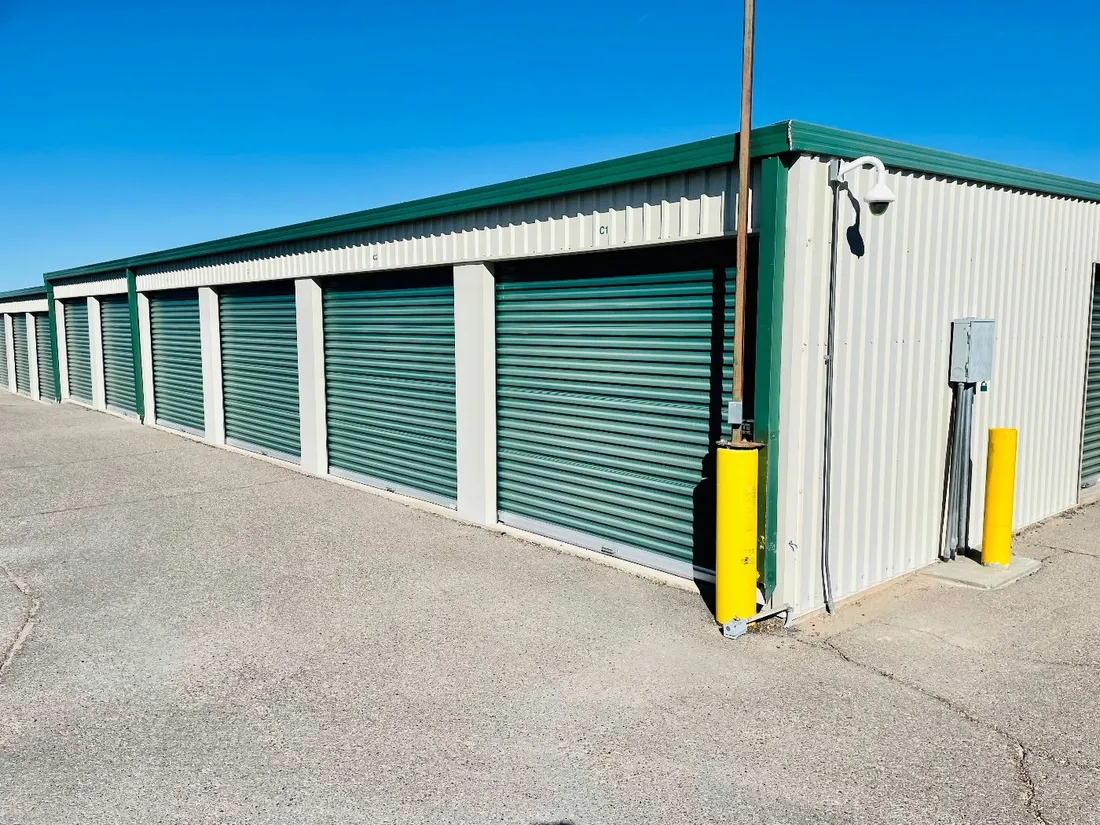 A row of drive-up storage units with green doors at The Storage Locker LLC in Albertville, Alabama